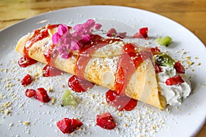 Mix fruit crape with strawberry sauce.