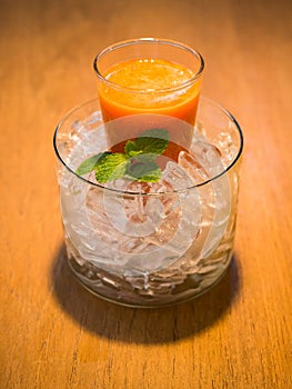 Mix fruite juice in glass with ice put on wood table