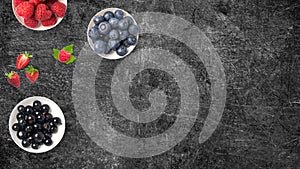 Mix of fruits on white bowls on dark background with copy space. Concept of juicy, fresh, organic and healthy. Top view of