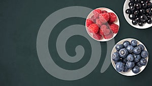 Mix of fruits on white bowls on dark background with copy space. Concept of juicy, fresh, organic and healthy. Top view of