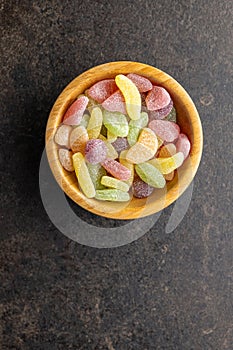 Mix of fruity jelly candy in wooden bowl. Top view