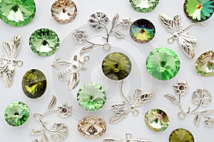 Green and gold crystals and metal bees and flowers and dragonflies on white background