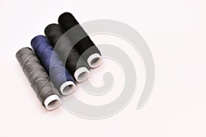 mix of grey, blue and black colored threads on white background - close up photography