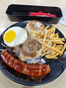 Mix grilled of jumbo sausage, egg, fries, chicken chop and mashed potato