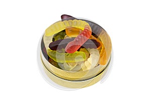 Mix of gummy worms in a round tin box isolated on white. Studio shot, top view, close-up