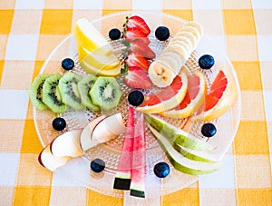 Mix of healthy fruits already cutted full of vitamins. Ready to eat. Colors of nature. Checkered tablecloth