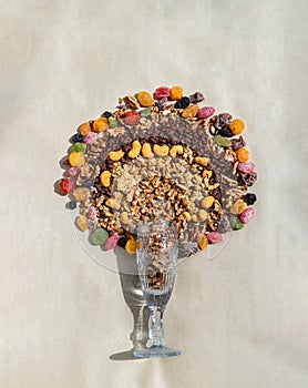 Mix of Healthy Snack of nuts and Other Dried fruits mix on tall crystal glass with gray background