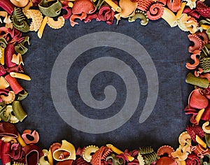 Mix of Italian pasta on dark textile background