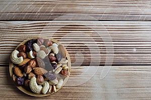 Mix of nuts and dried fruits at weathered wooden background