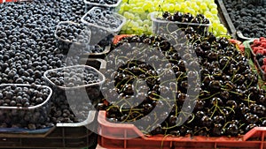 Mix of organic fruit in plastic box at local market ready to sell. Seasonal products in container in supermarket. Blackberry,
