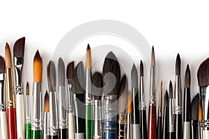 Mix of paint brushes in a row isolated on a white background. Top view