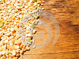 Colorful mixed cereals and legumes: rice, peas, lentils and pearl barley on a wooden background. View from above. Empty space for