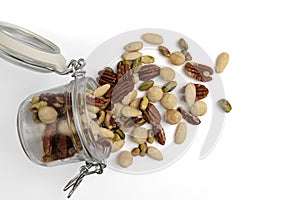 mix of peeled nuts in glass jar isolated on white