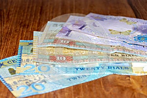 A mix of  small Omani Riyal Currency Bills spread out on the table