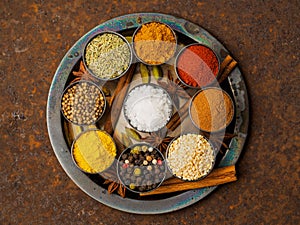 Mix spices on dark brown rusty metal plate - coriander seeds, gr
