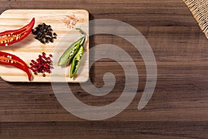 Mix of spices, grains of red and black pepper, pink himalayan salt and wooden box with cherry tomatoes