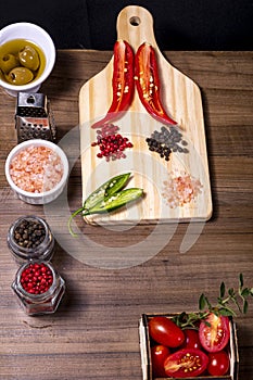 Mix of spices, grains of red and black pepper, pink himalayan salt and wooden box with cherry tomatoes