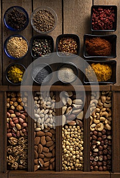 Mix of spices and mix of nuts on a wooden surface