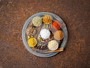 Mix spices on round metal plate - coriander seeds, ground red pe