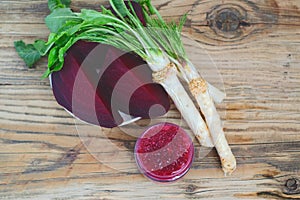 Mix spicy horseradish and beetroot in a small glass jar on a rustic wooden table. Organic food. top view