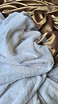 mix of textures white blanket and satin sheet fluffy tissue flowing woven weave suit evocative of a kiss