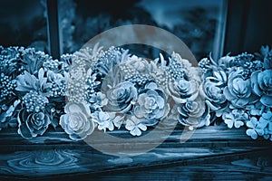 Mix types succulents and flowers on the windowsill on facade of the house, blue green background