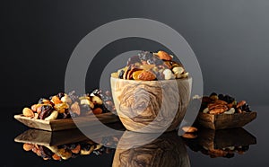 Mix of various nuts and raisins on a black reflective background