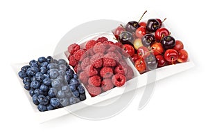 A mixed arrangement. Assorted berries including blueberries, raspberries and cherry, isolated on white background