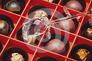 Mixed Belgian chocolates in a red box and crystal rose above them