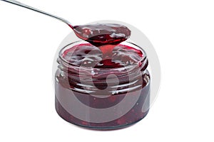 Mixed berry jam in glass jare with spoon isolated on a white