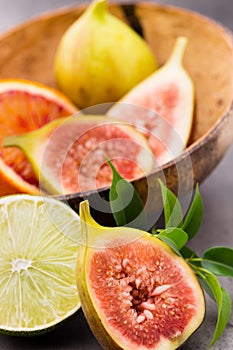 Mixed citrus fruit figs, limes on a gray background.