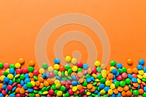 Mixed collection of colorful candy, on colored background. Flat lay, top view. frame of colorful chocolate coated candy