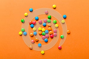 Mixed collection of colorful candy, on colored background. Flat lay, top view. frame of colorful chocolate coated candy