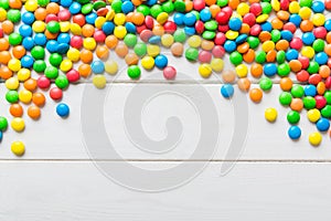 Mixed collection of colorful candy, on colored background. Flat lay, top view. frame of colorful chocolate coated candy