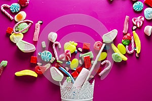 Mixed colorful candy on pink background, kids holidays