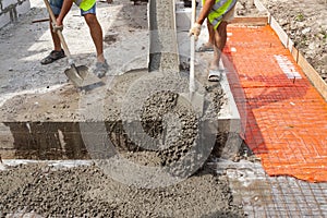 Mixed concrete pouring at construction site.