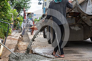 Mixed concrete pouring at construction site. Pouring cement during sidewalk upgrade.