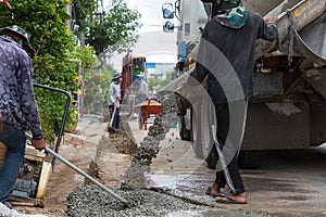 Mixed concrete pouring at construction site. Pouring cement during sidewalk upgrade.