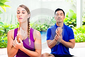 Mixed couple at yoga training in tropical Asia