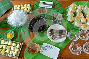 Mixed dessert in high tea break pineapple bread cream and ice black jelly with syrup on decoration leaf on wood table