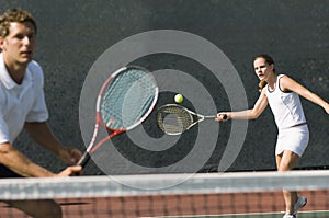 Mixed Doubles Player Hitting Tennis Ball