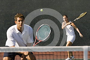 Mixed Doubles Player Hitting Tennis Ball