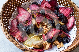 Mixed Dried Fruits Orange, Strawberry, Pineapple, Cherry and Apple Slices with Cinnamon Powder in Wooden Basket