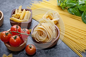 Mixed dried pasta selection on wooden background. composition of healthy food ingredients isolated on black stone background, top