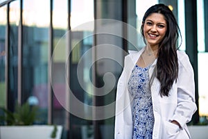 Mixed ethnicity college grad student in the medical field, possibly intern for dentistry, psychiatry, medicine, in lab coat