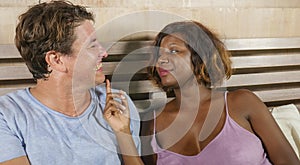 Mixed ethnicity couple in love cuddling together at home in bed with beautiful playful black African American woman and caucasian
