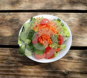 Mixed fresh salad on grunge wooden table