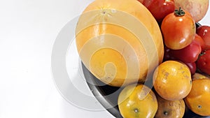 Mixed fruits, many include oranges, papaya, tomatoes and apples. Photo aside view to the left