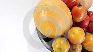 Mixed fruits, many include oranges, papaya, tomatoes and apples. Photo aside view to the left photo