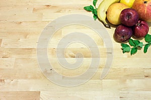 Mixed fruits on wooden table with banana, mangoes, apples and herbs. Healthy food concept for vegetarian, vegan, raw, fru